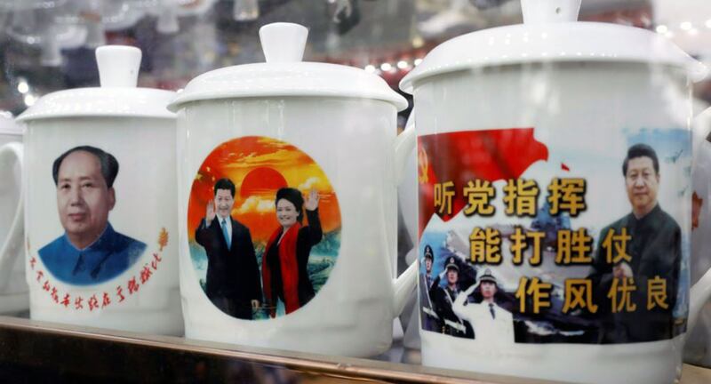 资料图片:北京一家商店展示的带有中国国家主席习近平形象的纪念品水杯,一个杯子上有口号“听党指挥,能打胜仗,作风优良”。(路透社)