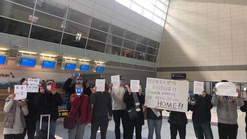 部分华人在美国一机场内举牌要求中国驻华大使馆允许他们前往中国（北美华人e网）