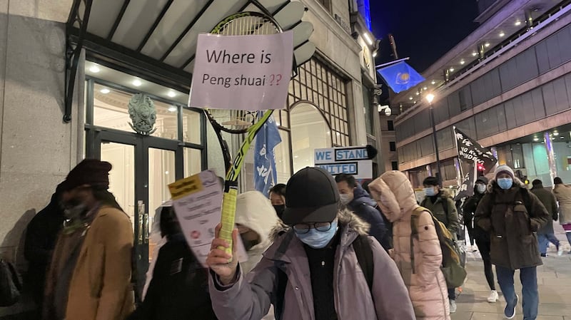 有游行人士举起网球拍,展示写上“彭帅在哪里?”(Where is Peng Shuai?)字句的标语,表达对中共噤声的不满。(吕熙摄)