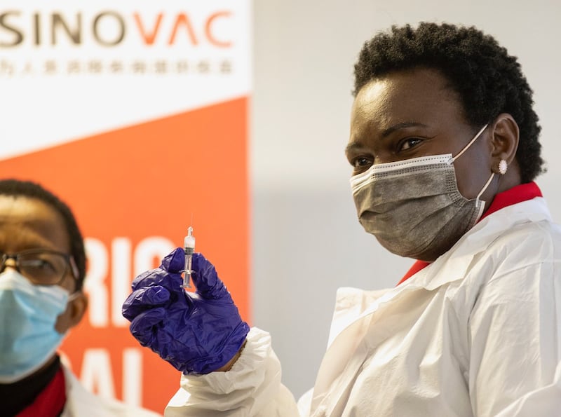 2021 年 9 月 10 日,在南非比勒陀利亚,一名医护人员在为未成年人接种疫苗之前持有 Sinovac 疫苗。南非于周五开始第三阶段 Covid-19 临床试验,调查 Sinovac 疫苗对儿童的疗效。 (美联社)