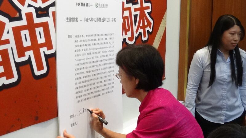 民进党立委尤美女签名连署基进党提出的《境外势力影响透明法》草案。(记者夏小华摄)