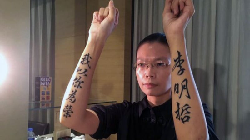 李妻李净瑜2017年9月11日赴陆会见丈夫,在双臂刺青“李明哲我以你为荣”力捍丈夫尊严。(资料照、李明哲救援大队提供)