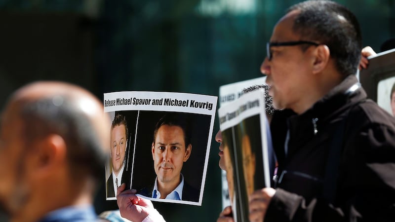 2019年5月8日中国华为高管孟晚舟在加拿大温哥华出庭。法庭外民众举着被中国逮捕的加拿大公民康明凯和斯帕弗的照片,要求中国放人。(路透社)