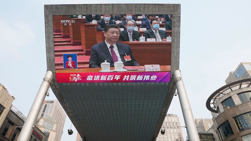 2021年3月11日,在北京一大屏幕上显示习近平在人大会闭幕会议。 (美联社)