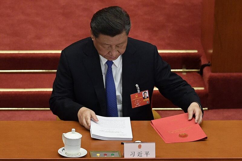 图为,2020年5月28日,习近平在北京人民大会堂举行的全国人民代表大会闭幕会议时准备文件。(法新社)