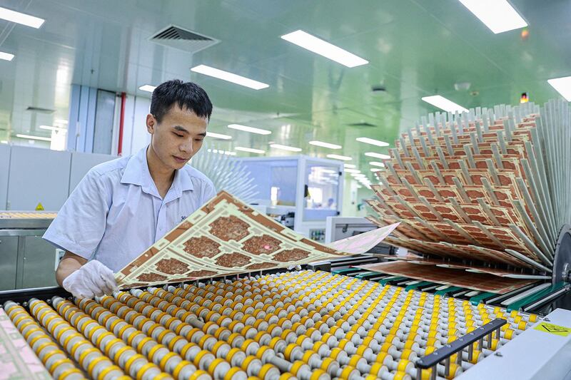 2024年7月24日,江西省九江市工厂的员工在生产出口用的印刷电路板。(法新社)