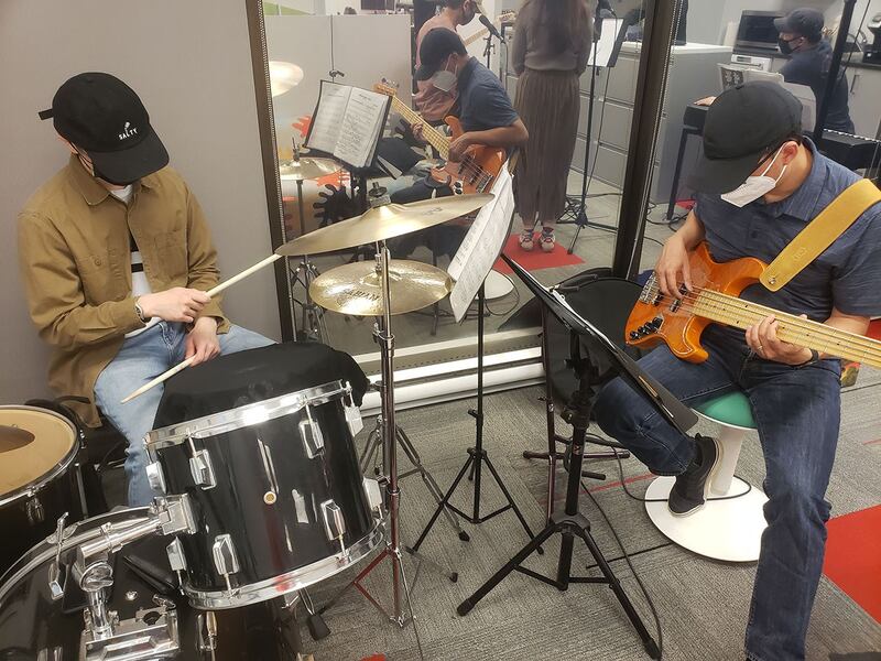 乐队中的贝斯手艾伦和鼓手艾那肯一起弹奏击乐。 (记者柳飞拍摄)