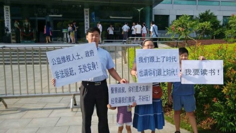 深圳春风劳动争议服务部负责人张治儒(左)被捕前带领家人在街头抗议(Public Domain)