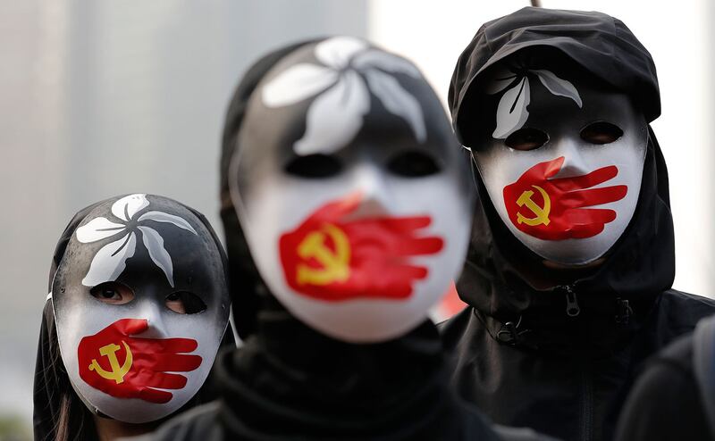 图为,2019年12月22日,身着黑衣蒙面示威者在香港中心地带集会,声援维吾尔族及香港人权自由。 (美联社)