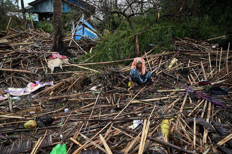 A Rohingya woman sits amid the shattered remains of her home in the Basara refugee camp in Sittwe, Myanmar, on Tuesday, May 16, 2023. Credit: AFP