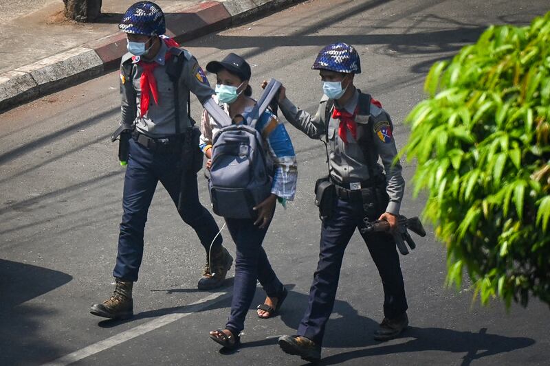 ၂၀၂၁ ခုနှစ် ဖေဖော်ဝါရီလ ၂၇ ရက်နေ့က ရန်ကုန်မြို့တွင် ပြုလုပ်သည့် စစ်အာဏာသိမ်းမှု ဆန့်ကျင်ရေး ဆန္ဒပြပွဲတစ်ခုအတွင်း သတင်းထောက် မကေဇွန်နွေးအား ရဲတပ်ဖွဲ့က ဖမ်းဆီးသွားစဉ်။ (Photo - Ye Aung Thu/AFP)