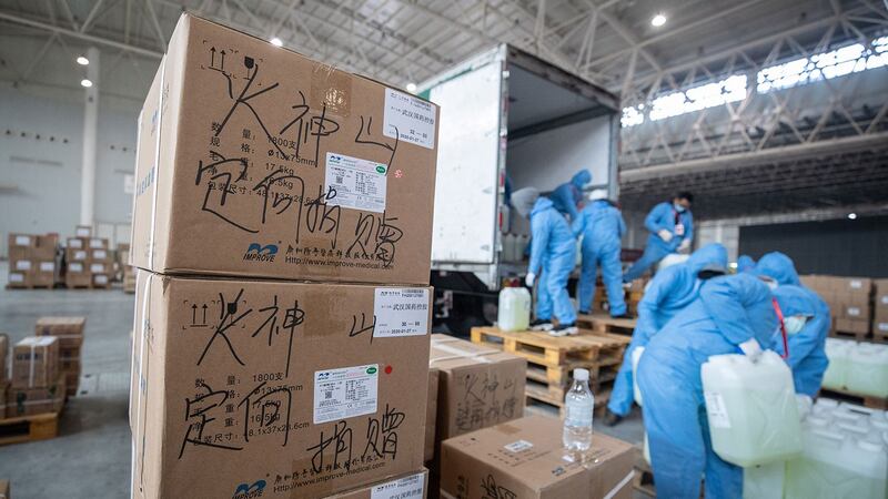 2020年2月4日,工作人员和志愿者在武汉市会展中心的仓库搬运医疗用品,该中心改建为临时医院。(法新社)
