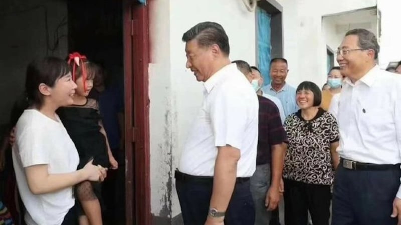 中国领导人习近平2020年8月18日在安徽省阜南县探访一户家庭,一名怀抱孩子的受灾群众被发现是乔装的当地公安。(新华视点/乔龙提供)
