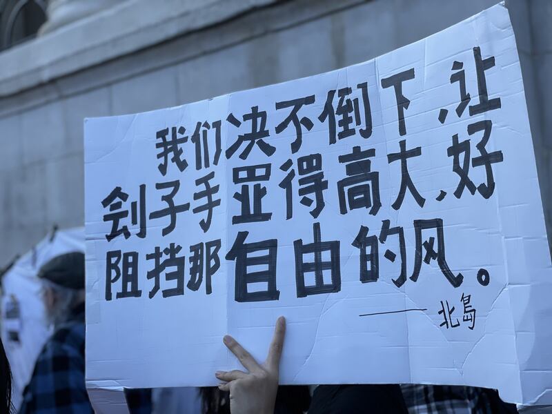 不少中国留学生手持鲜花和自制标语,默默加入集会。(吕熙拍摄)