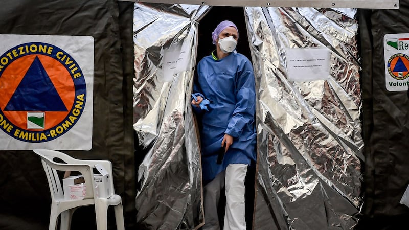 意大利民防局近日在意北城市的皮亚琴察医院急诊诊室设置帐篷,收治疑似患者。图为,2020年2月27日,医护人员从帐篷出来。(美联社)
