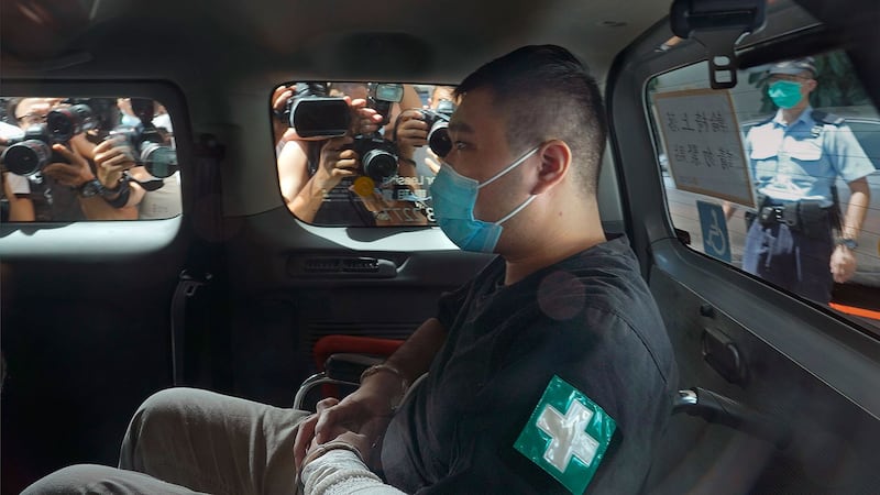 2020年7月6日,香港首位被控涉嫌违反国安法的男子唐英杰坐着轮椅由警车押解至法庭。(美联社)