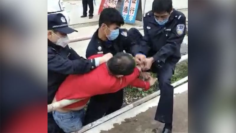 一男子拒未戴口罩被三名公安控制。(视频截图/乔龙提供)