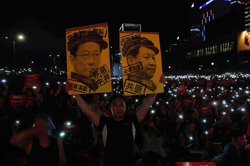 2019年6月26日，在香港集会上抗议者手持标牌“习近平与韩正画像”。（美联社）