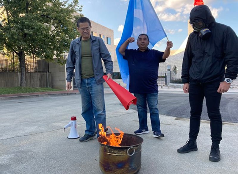 活动参加者将要焚烧的旗帜放向火盆(伊利夏提提供)