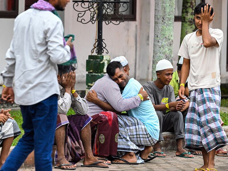 Rohingya refugees embrace each other after taking part in Eid al-Fitr prayers at a temporary shelter in Meulaboh, Indonesia, April 10, 2024.