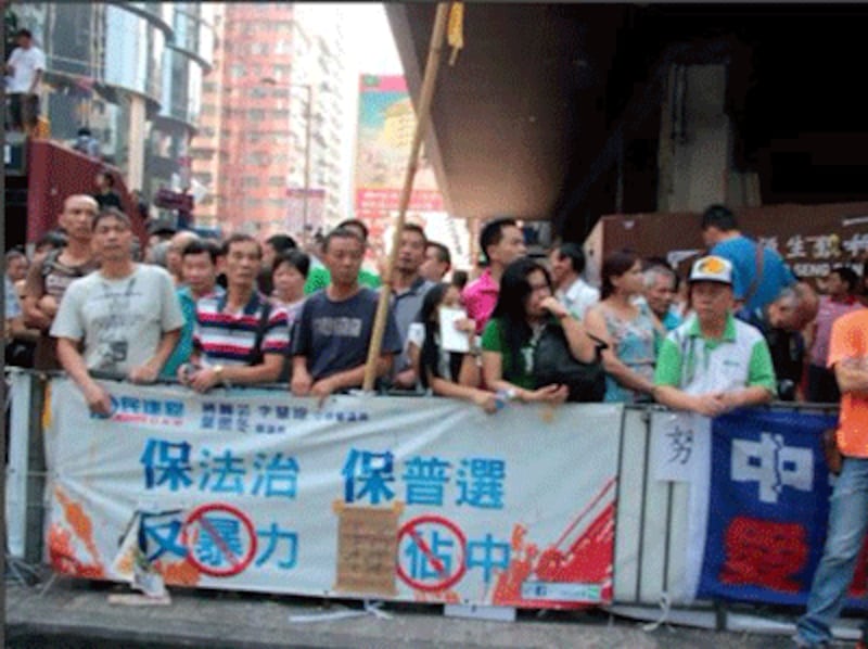 A crowd behind an anti-Occupy banner in Mong Kok, Oct 5, 2014. (RFA Photo)