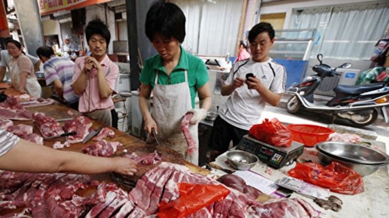 贸易战影响中国股市、楼市等消费品领域,其中末端消费者受到的伤害最大,民众基本生活用品近期也出现价格急升的现象,蔬菜、水果、肉类涨价的幅度都非常大。图为安徽淮北某市场,市民们在选购猪肉。(AFP)