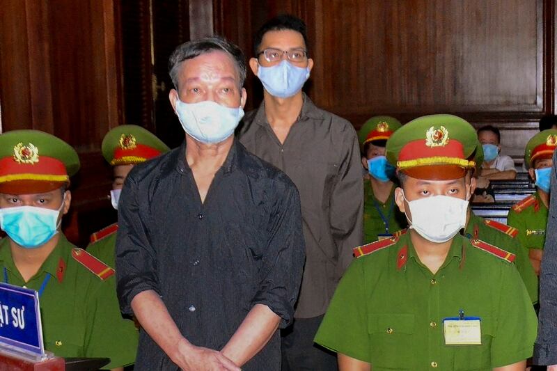 This Jan. 5, 2021, image released by the Vietnam News Agency shows Vietnamese journalist Le Huu Minh Tuan, rear center, and blogger Tuong Thuy, during their trial in Ho Chi Minh City.