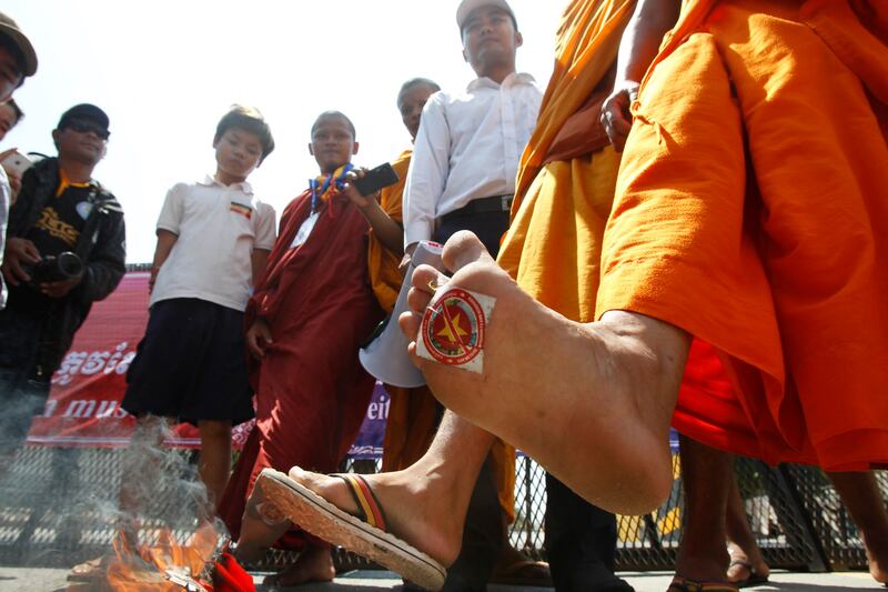 A Cambodian Buddhist monk walks with a Vietnamese national flag sticker on the bottom of his foot during an anti-Vietnam march in Phnom Penh, Oct. 4, 2014. (Heng Sinith/AP)