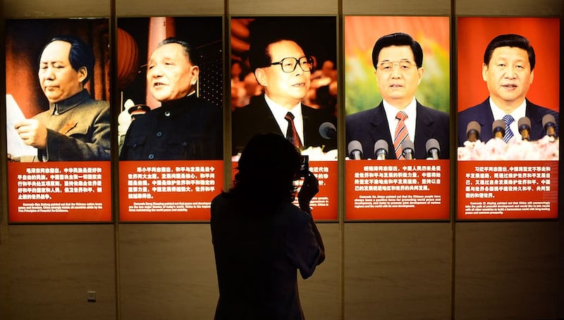 中国五代领导人毛泽东、邓小平、江泽民、胡锦涛、习近平的画像前走过。(法新社)