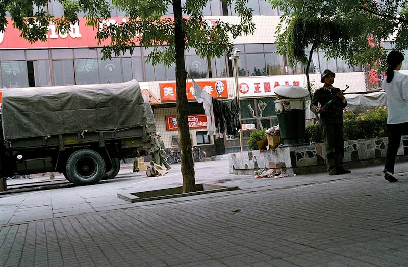 天安门镇压行动之后的六月十日,一名解放军士兵在当时北京唯一的西式快餐店前端枪警戒。(美联社资料图片)