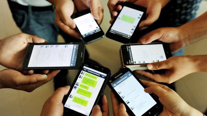 资料图片:手机用户展示微信页面。 (法新社)