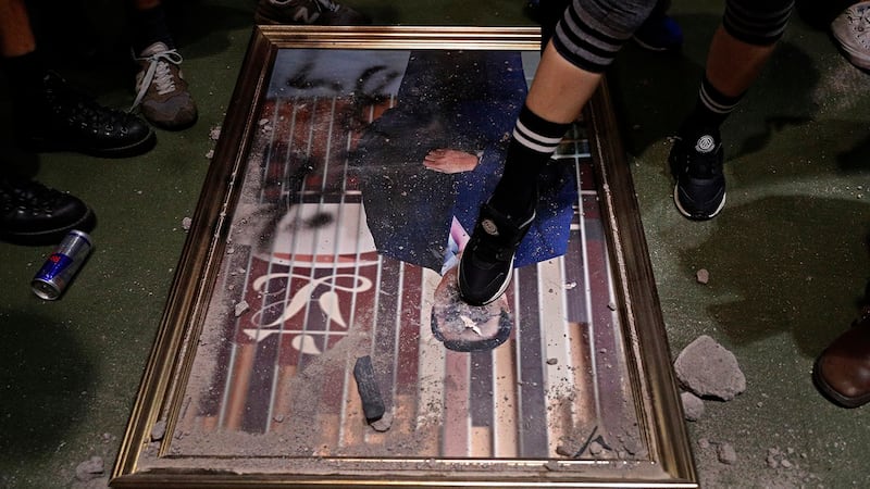 香港反对《逃犯条例》修订示威人士冲进香港立法会大楼拆下立法会领袖画像踩踏。(美联社)