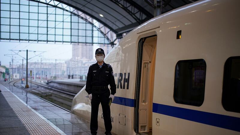 2020年4月8日,警察站在高速火车的旁边,这是两个月以来第一趟从武汉汉口火车站出发的火车,因冠状病毒病(COVID-19)爆发的中心城市的出行限制在武汉市通过公路,铁路和飞机离开城市。(路透社图片)