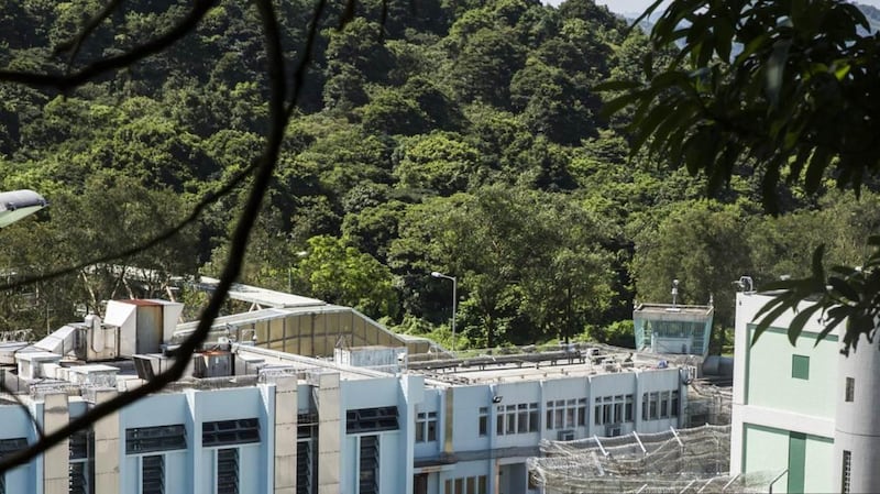 透过外墙,可看见壁屋惩教所内的建筑物。张梓轩(化名)曾透过日间活动室旁的天井,往下探头看见因被判入教导所而羁押在壁屋惩教所的青少年,被要求正午于操场上晒热的水沟盖上做伏地挺身。(摄影/AFP/ISAAC LAWRENCE)