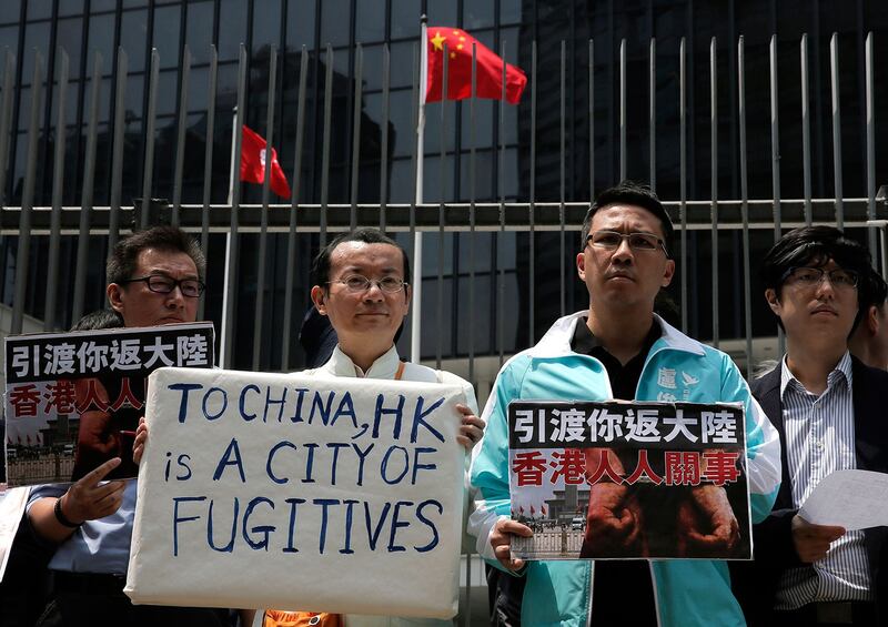 2019年4月3日,抗议者举起反对港府修订《逃犯条例》的标语。(美联社)