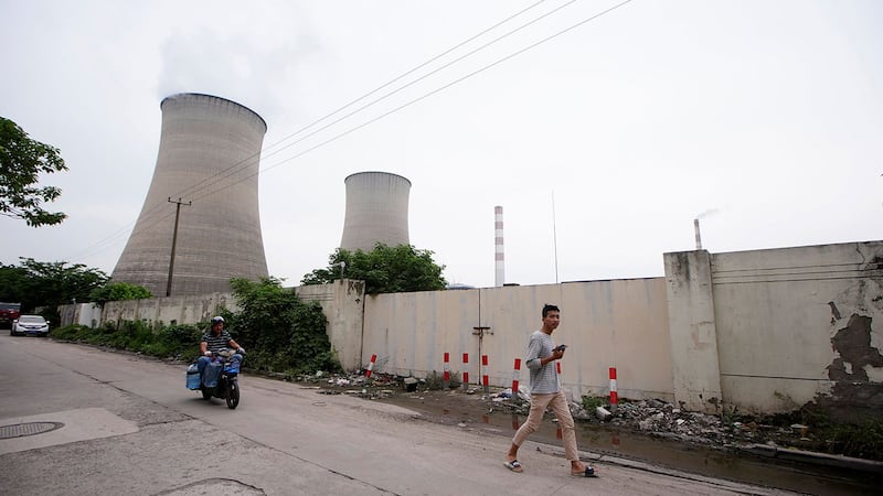 一名男子走过中国上海的一座燃煤电厂。(路透社)