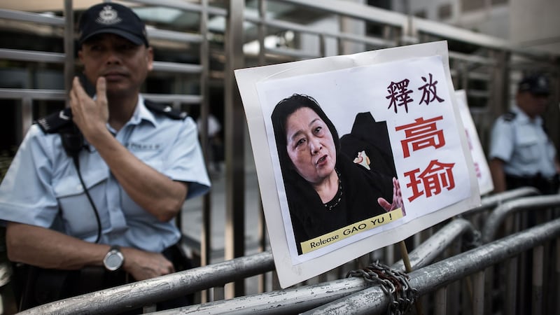 2015年4月17日,香港中联办大楼前的铁栅上,示威者插上要求释放高瑜的标语牌。(AFP)