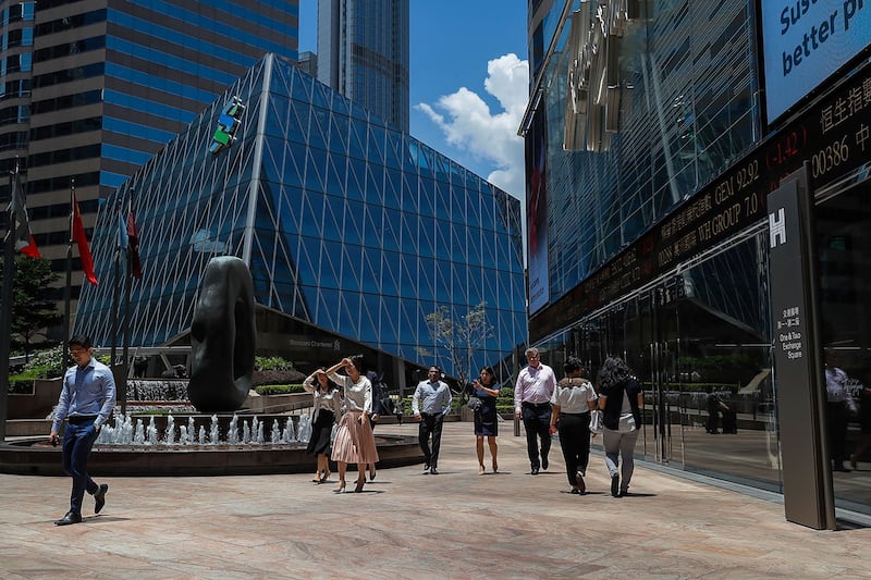 有舆论认为,特朗普反制中国的措施,反而令香港国际金融中心的地位更加重要。图为2019年8月5日,办公室工作人员走过一个电子板,显示5日香港金融区的股票价格。(美联社)