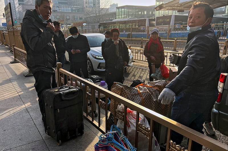 2023年1月6日携带行李在北京西站等候火车的农民工（美联社）