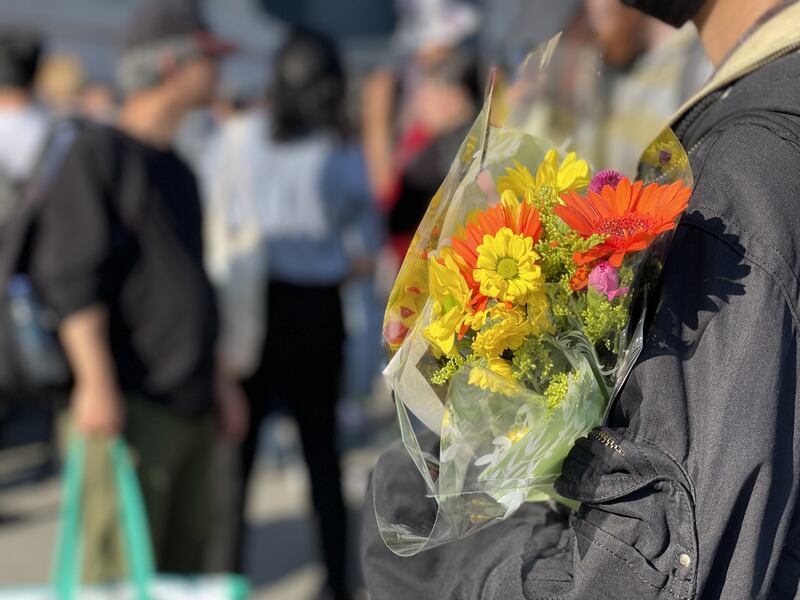 不少中国留学生手持鲜花和自制标语,默默加入集会。(吕熙拍摄)