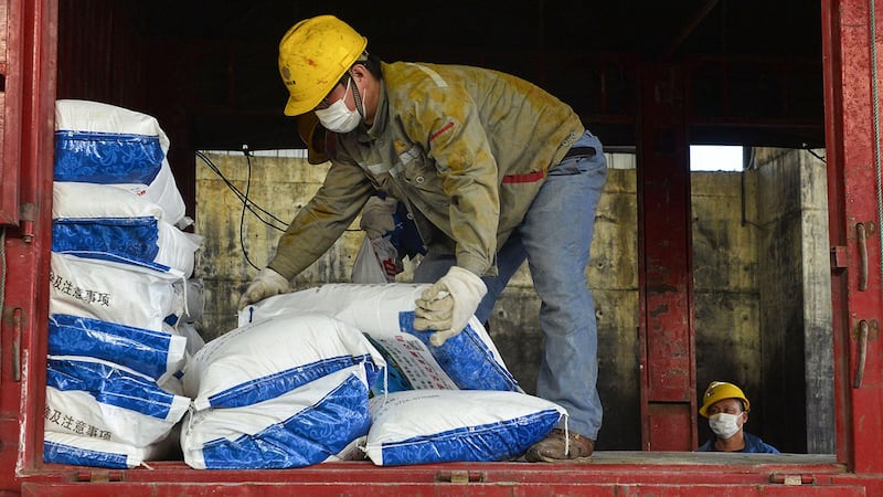 学者担心征用措施会被滥用。图为2020年1月30日,一名工人在湖北省孝感市的一家工厂运送消毒剂袋。(法新社)