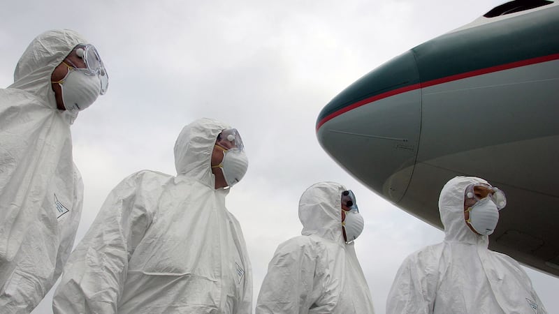 2020年1月1日,武汉的防疫工作显得异常紧张,在武汉机场的出发航班上,有全副保护衣人员上机检疫。(资料图/法新社)