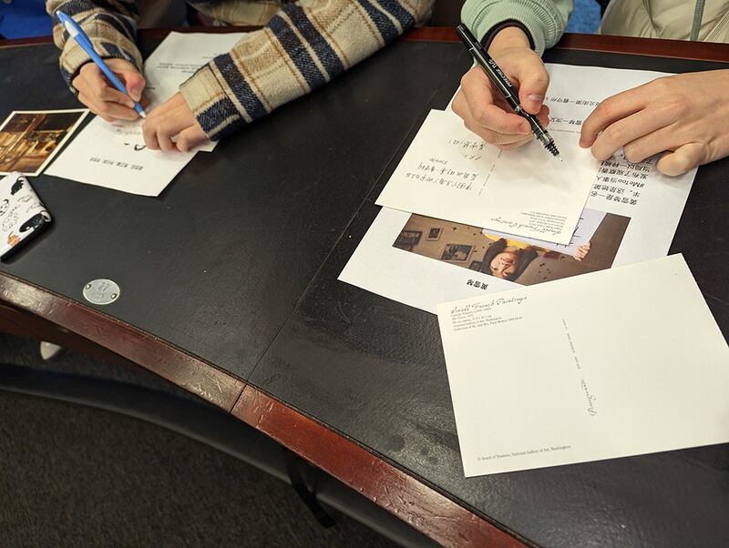 出席讲座观众写明信片(记者陈品洁拍摄)