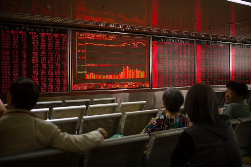 美国宣布加征关税后,中国和香港的股票市场不跌反升。图为2019年5月10日,市民在北京一经纪公司观看股票。(美联社)