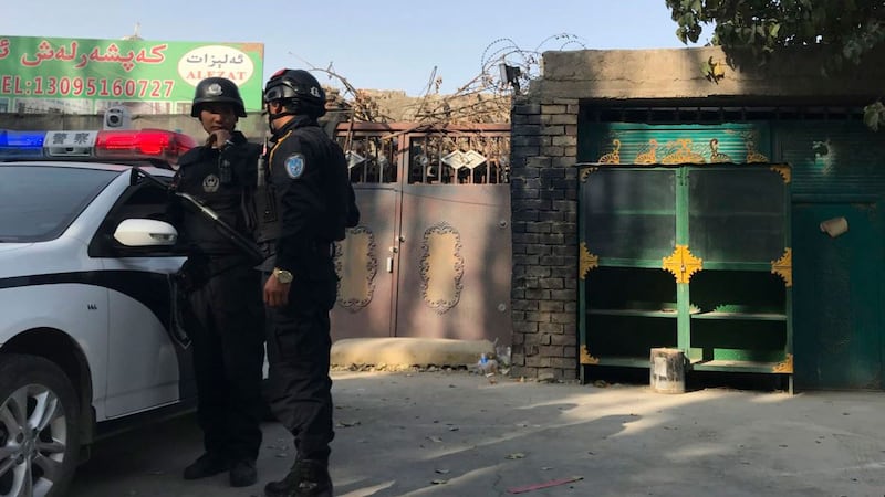 图为2017年11月2日,在新疆库尔勒市,警察站在再教育中心的附近。(AP)