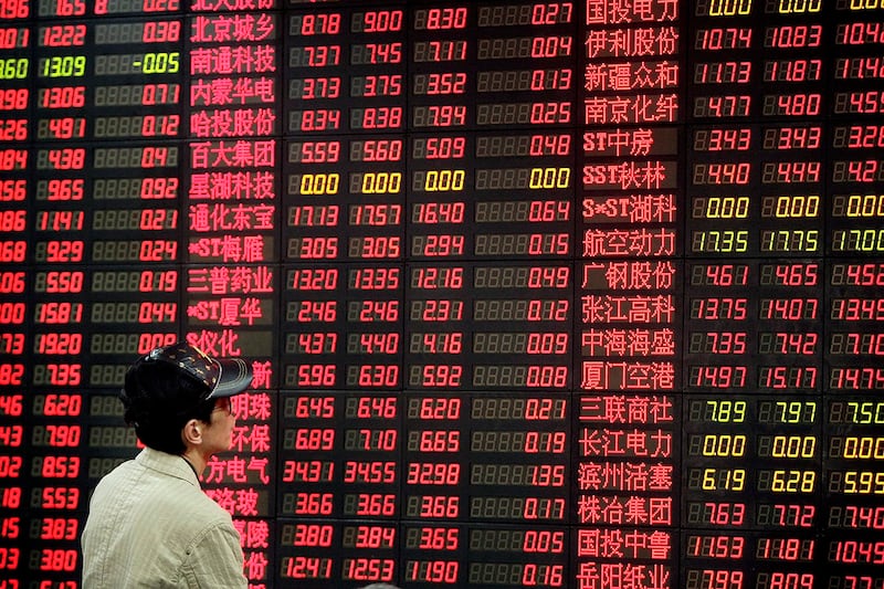 中国财政部要打造金融"国家队"的消息刺激沪深股市在4月26日微升。图为股民在观看股票牌价。(美联社图片)